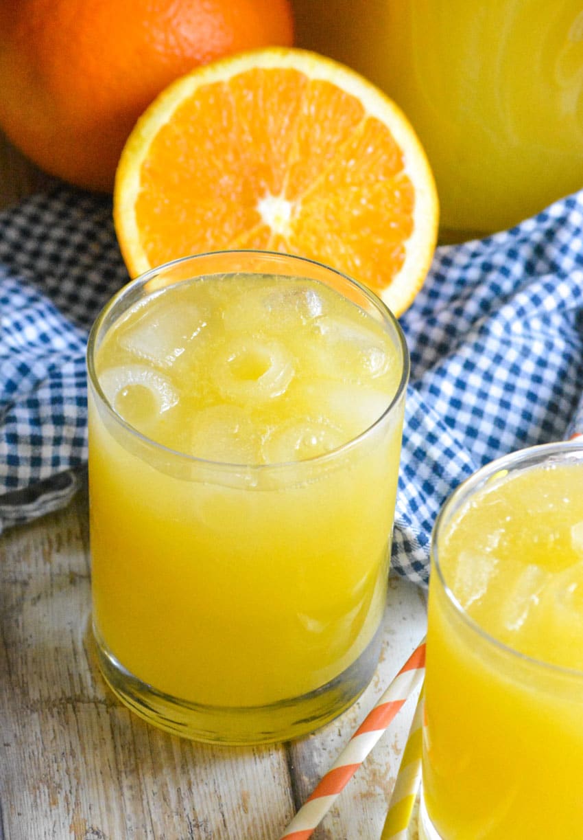 a glass of homemade orangeade on a wooden table