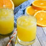 two glasses of homemade orangeade on a wooden table