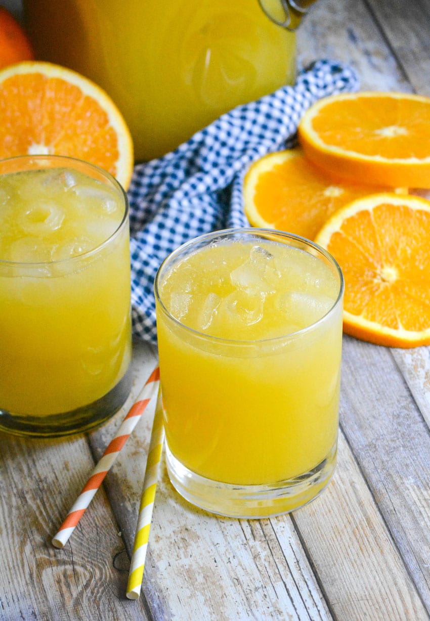 two glasses of homemade orangeade on a wooden table