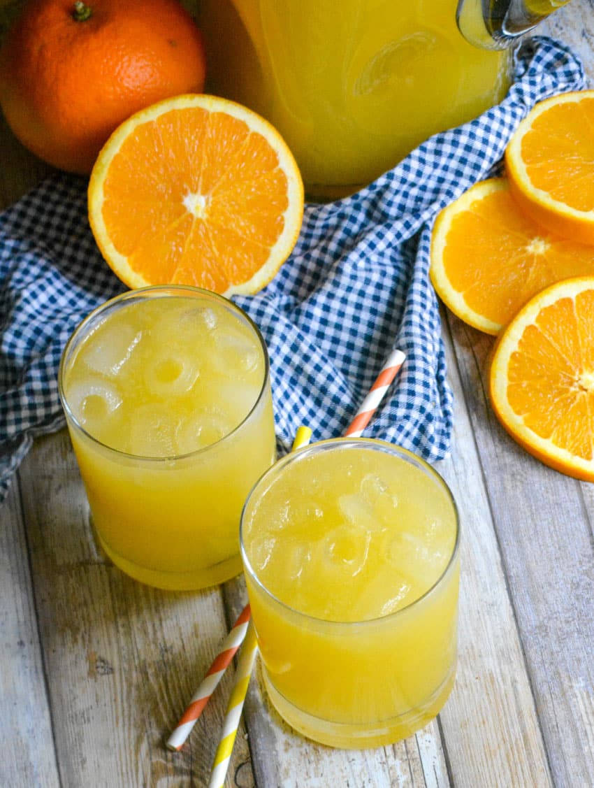 two glasses of homemade orangeade on a wooden table