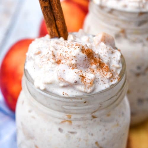 two glass mason jars filled with creamy peach overnight oatmeal