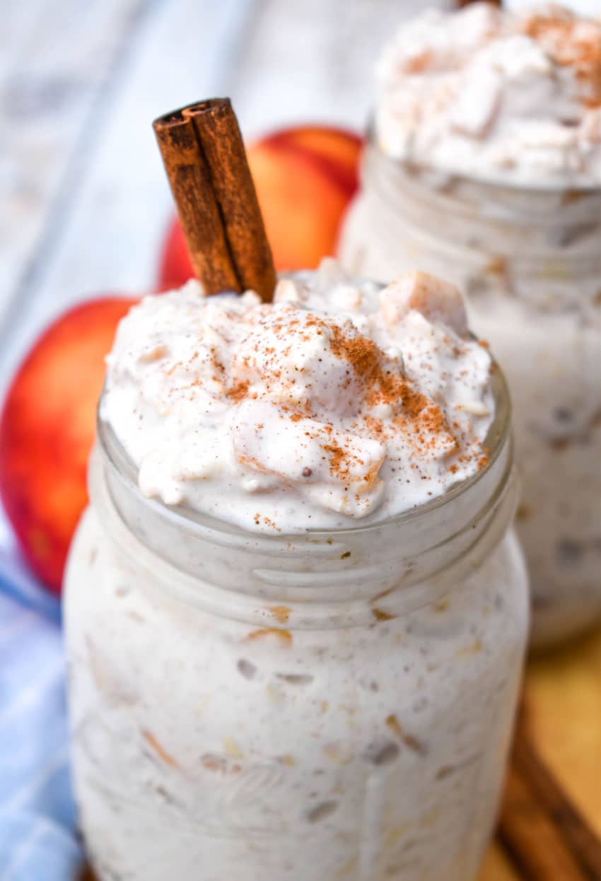 two glass mason jars filled with creamy peach overnight oatmeal