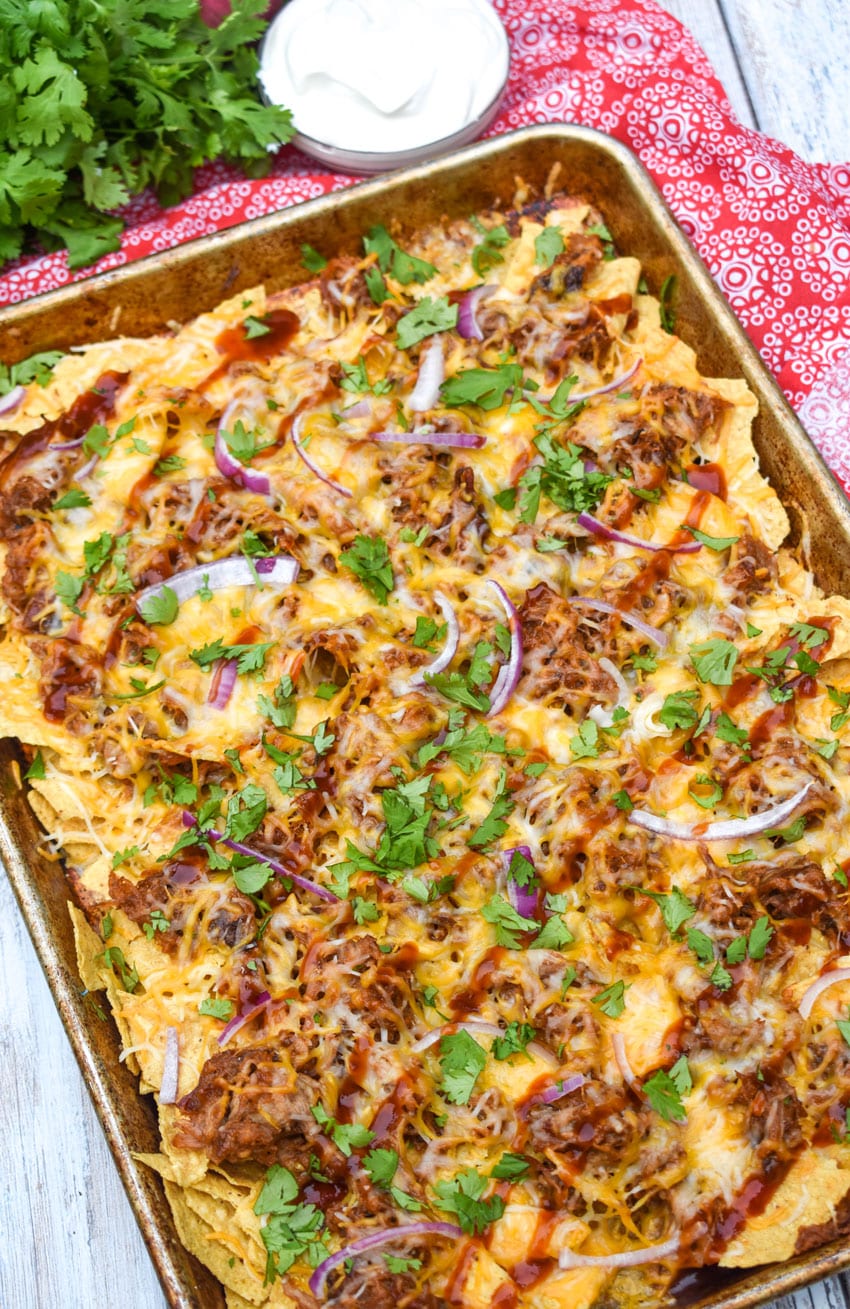 barbecue pulled pork nachos on a metal sheet pan
