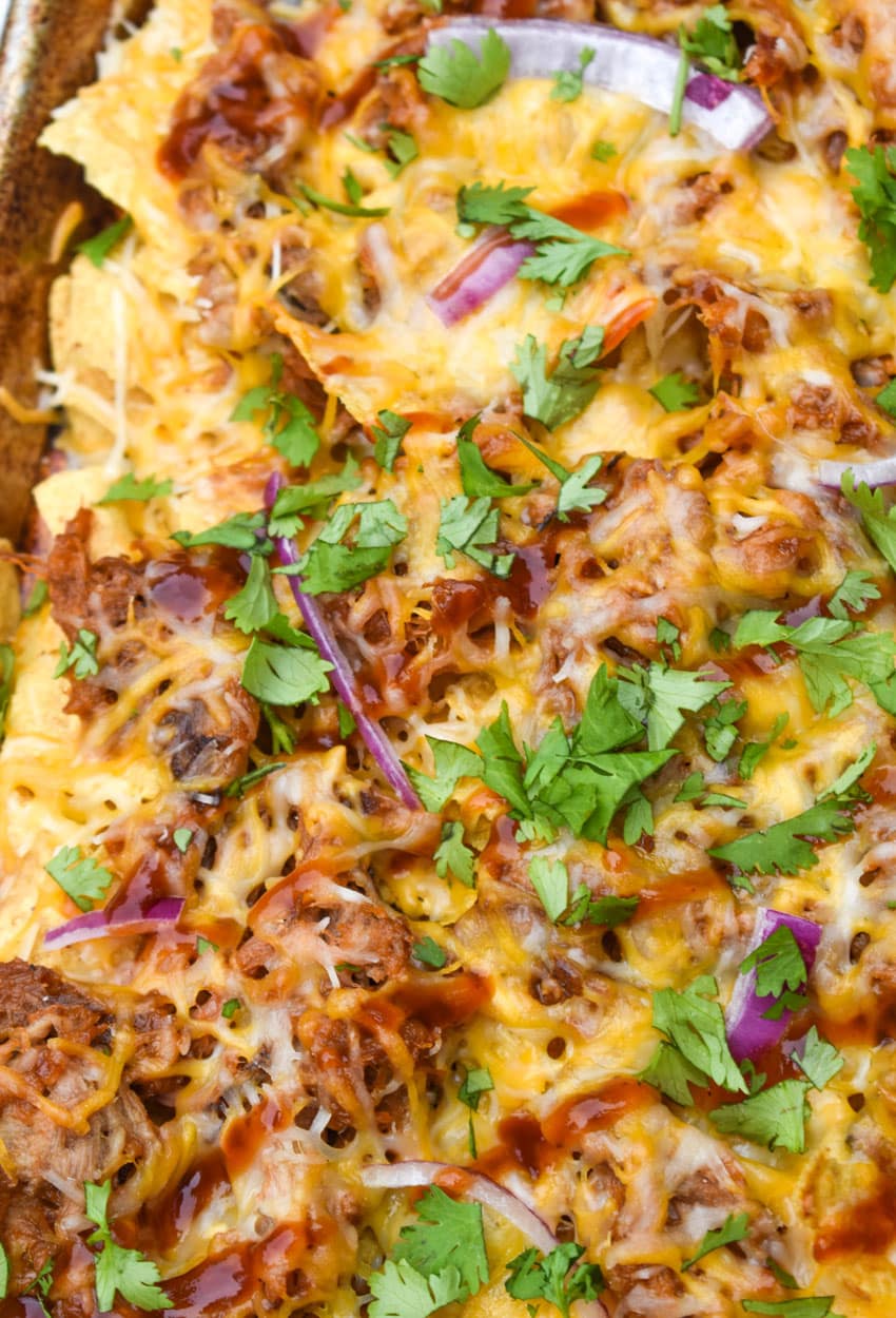 barbecue pulled pork nachos on a metal sheet pan
