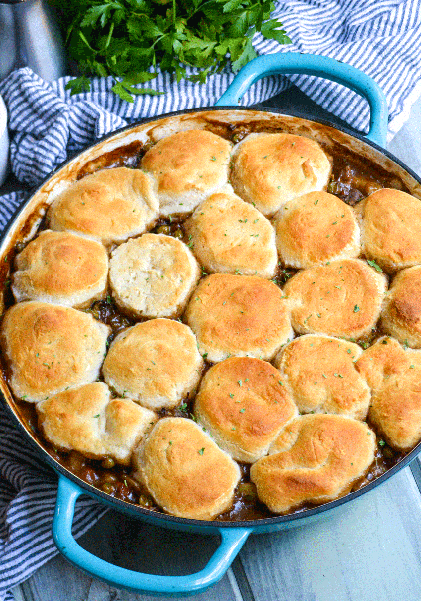 easy beef pot pie recipe with biscuit topping in a blue enameled cast iron skillet