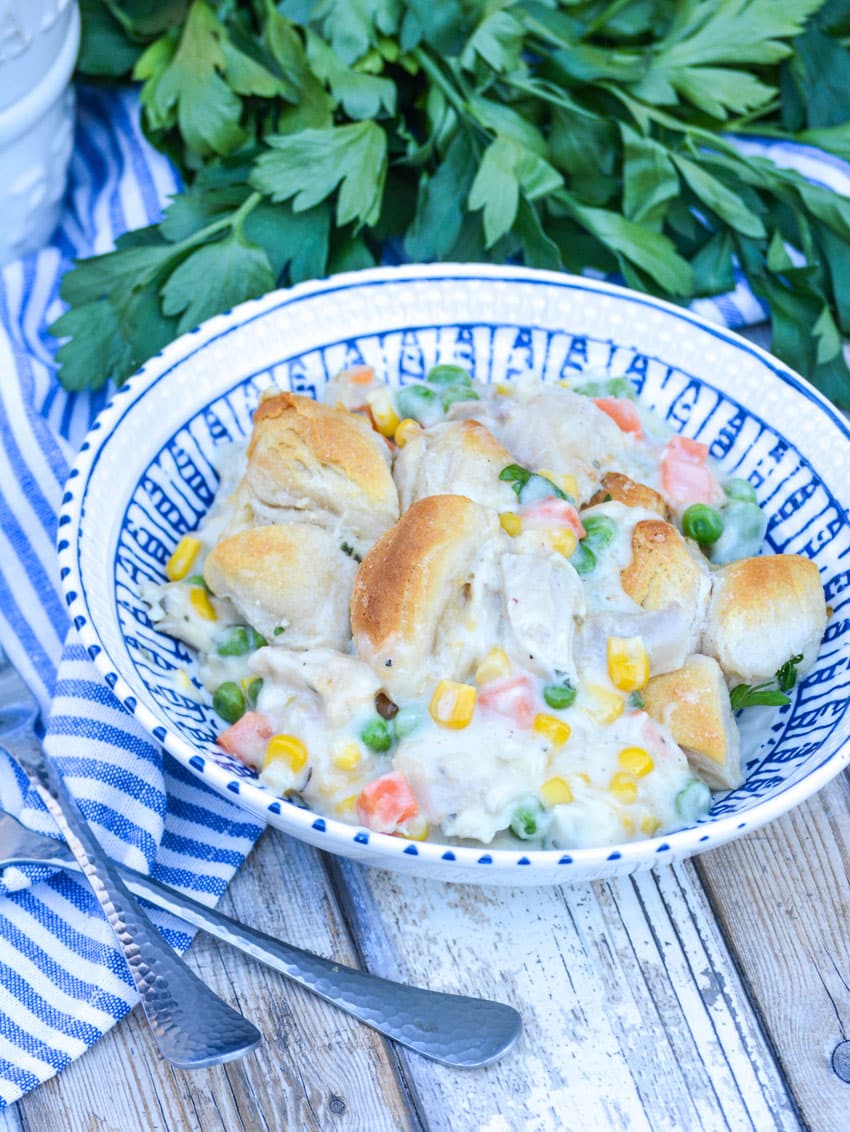 chicken pot pie casserole served in a blue and white bowl with silver forks on the side
