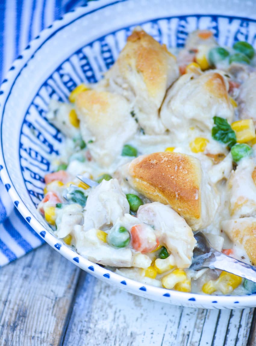 chicken pot pie casserole served in a blue and white bowl with silver forks on the side
