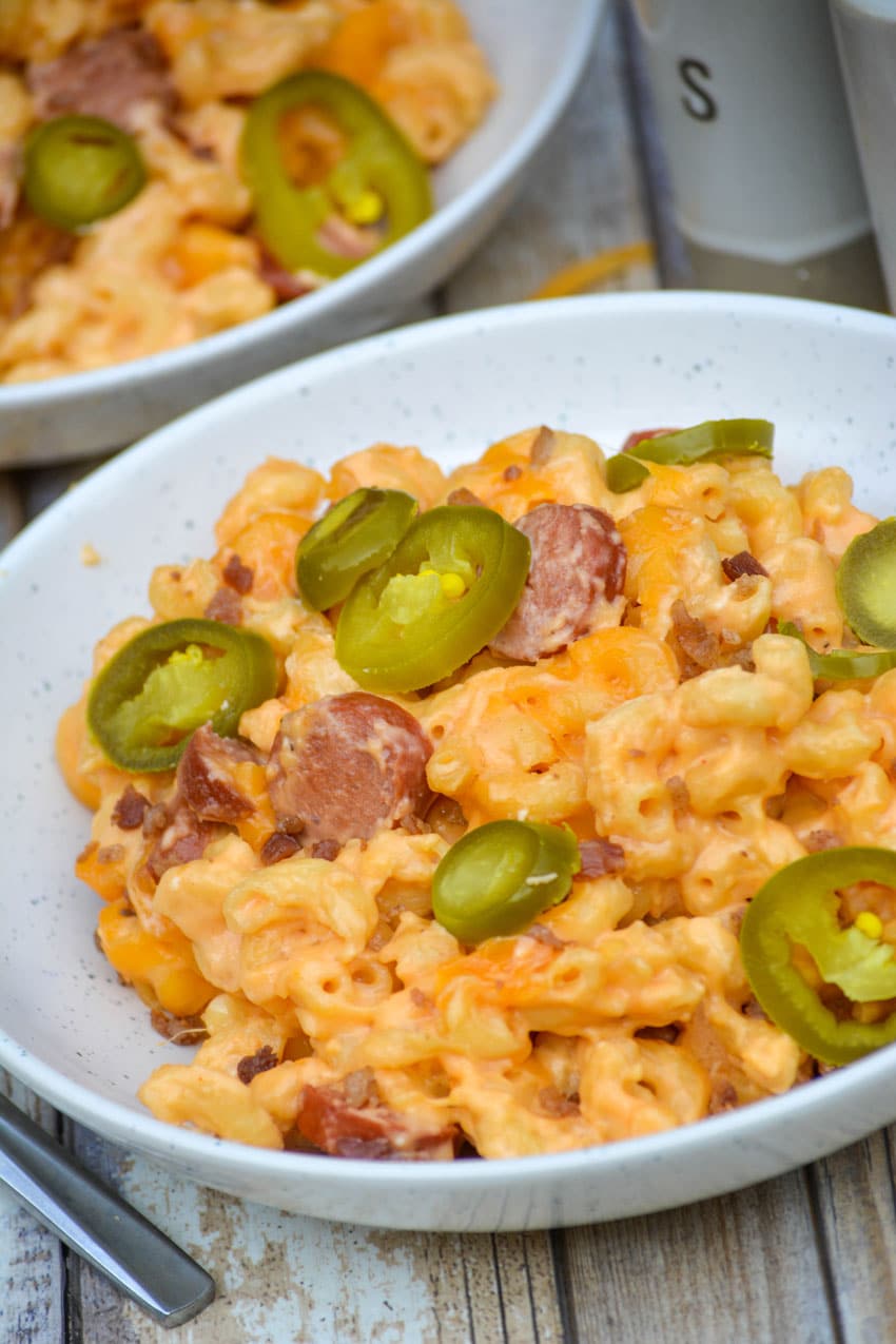 firehouse mac and cheese in two white bowls topped with sliced jalapenos
