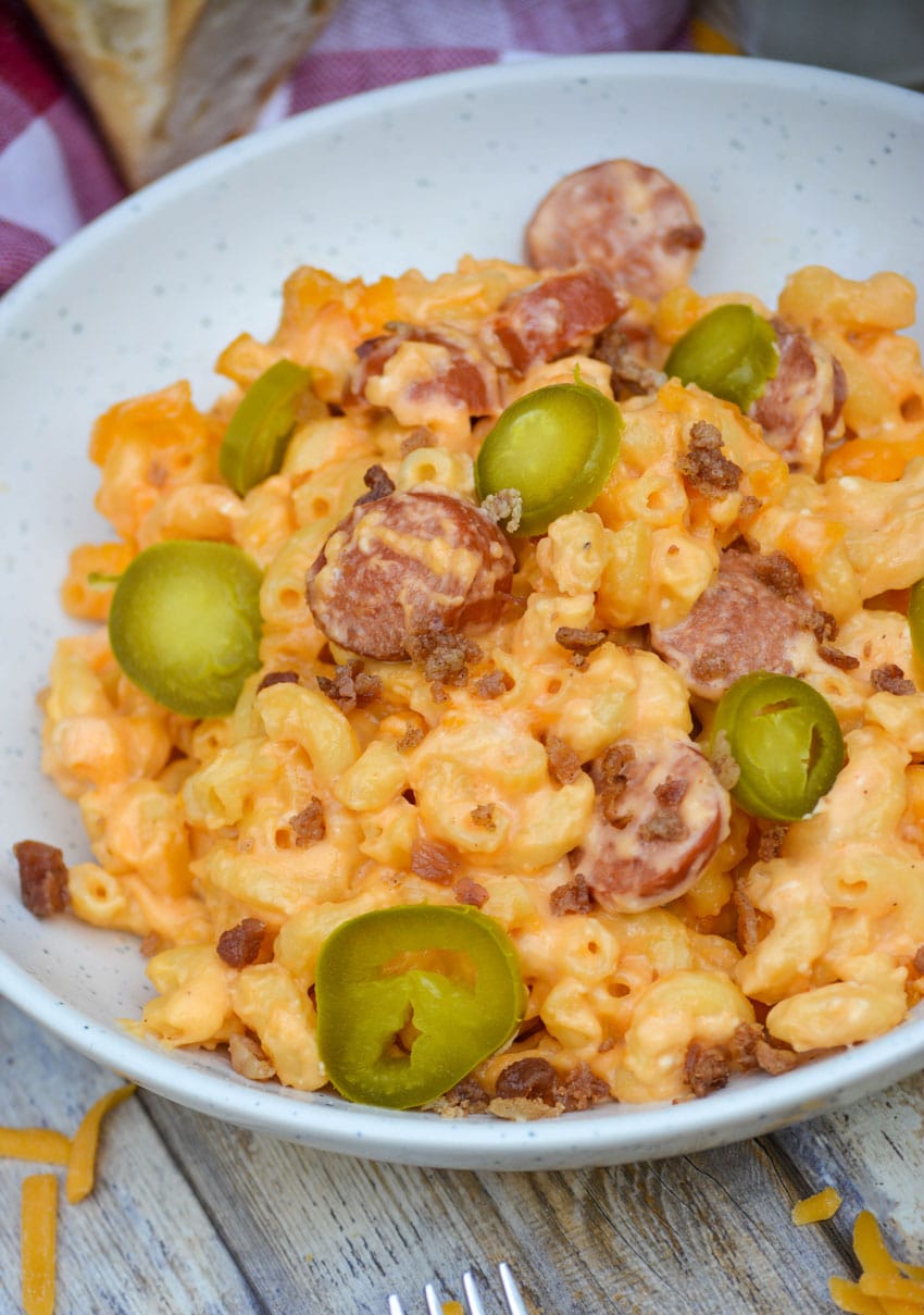 firehouse mac and cheese in two white bowls topped with sliced jalapenos