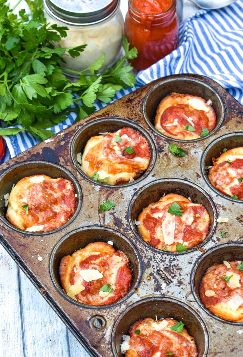 mini deep dish pizzas in a metal muffin tin