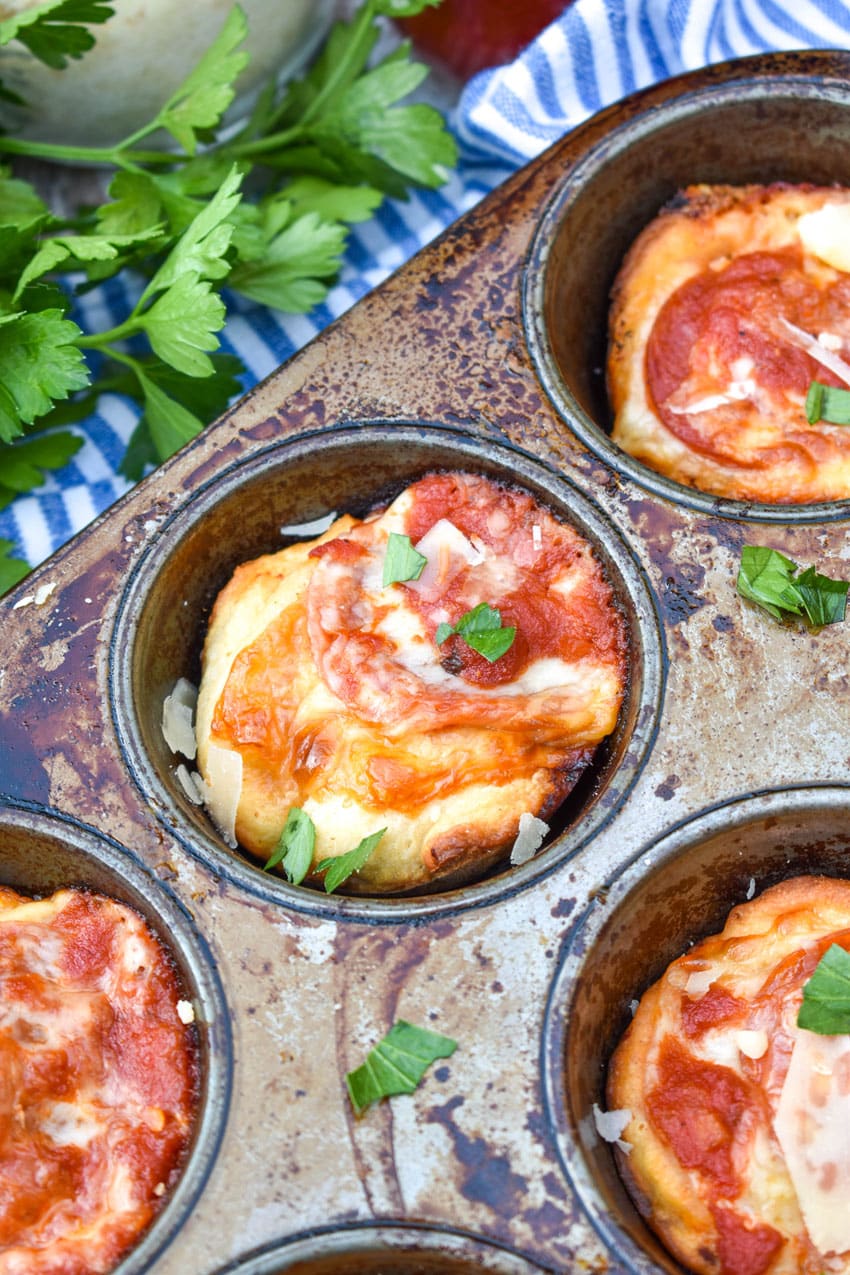 mini deep dish pizzas in a metal muffin tin