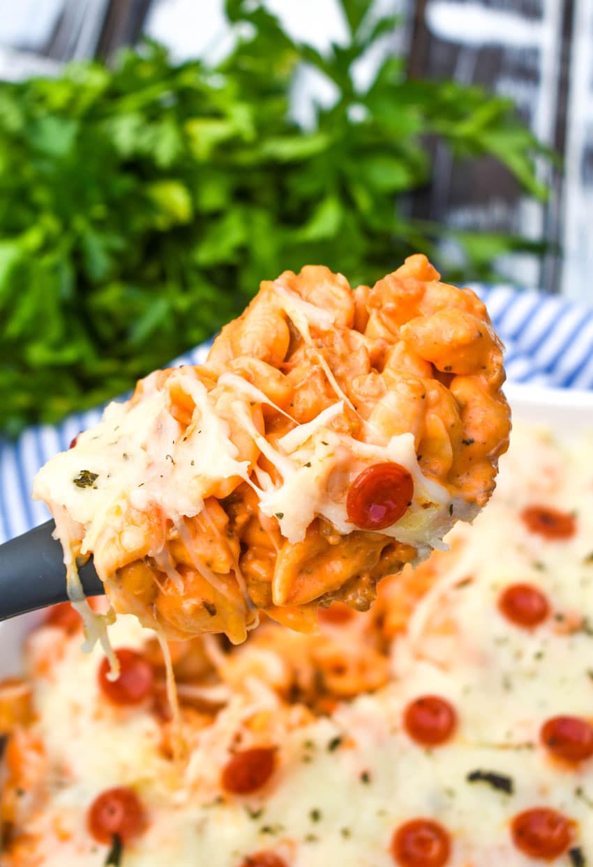 a spoon holding up a scoop of pizza mac and cheese