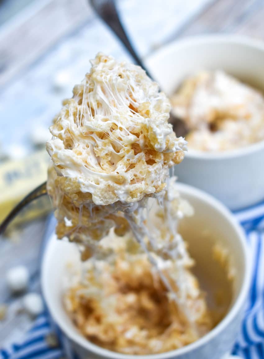 a silver fork holding up a scoop of microwave mug rice krispies treat