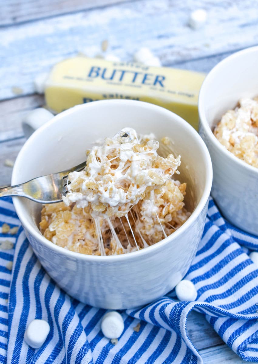 a silver fork stuck in a microwave rice krispie treat in a mug