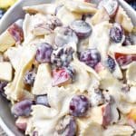 sweet pasta salad with fruit and honey in a white bowl surrounded by fresh fruits