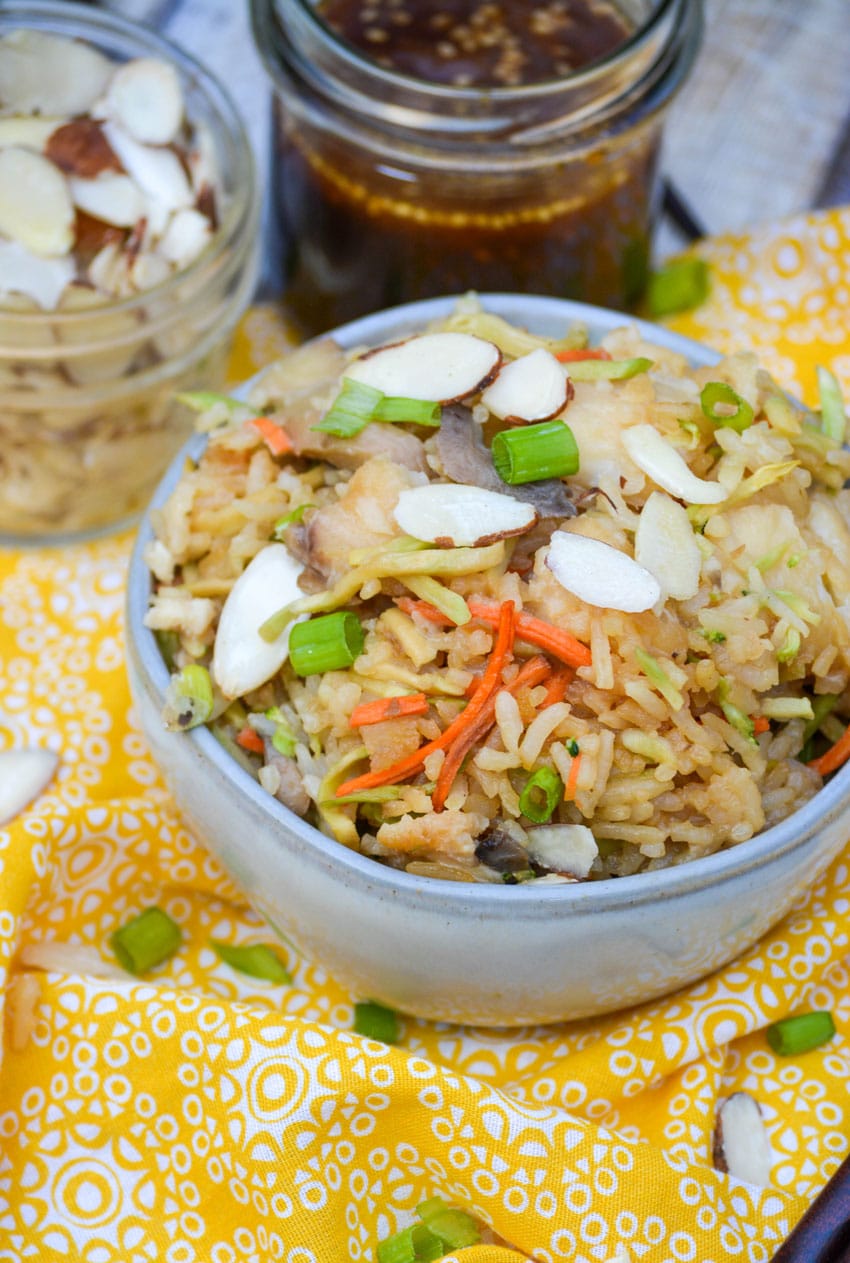 rice casserole with tilapia fish in a small gray bowl topped with slivered almonds