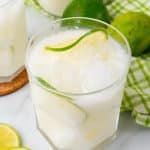 creamy Brazilian lemonade in a drinking glass with slices of lime and ice cubes