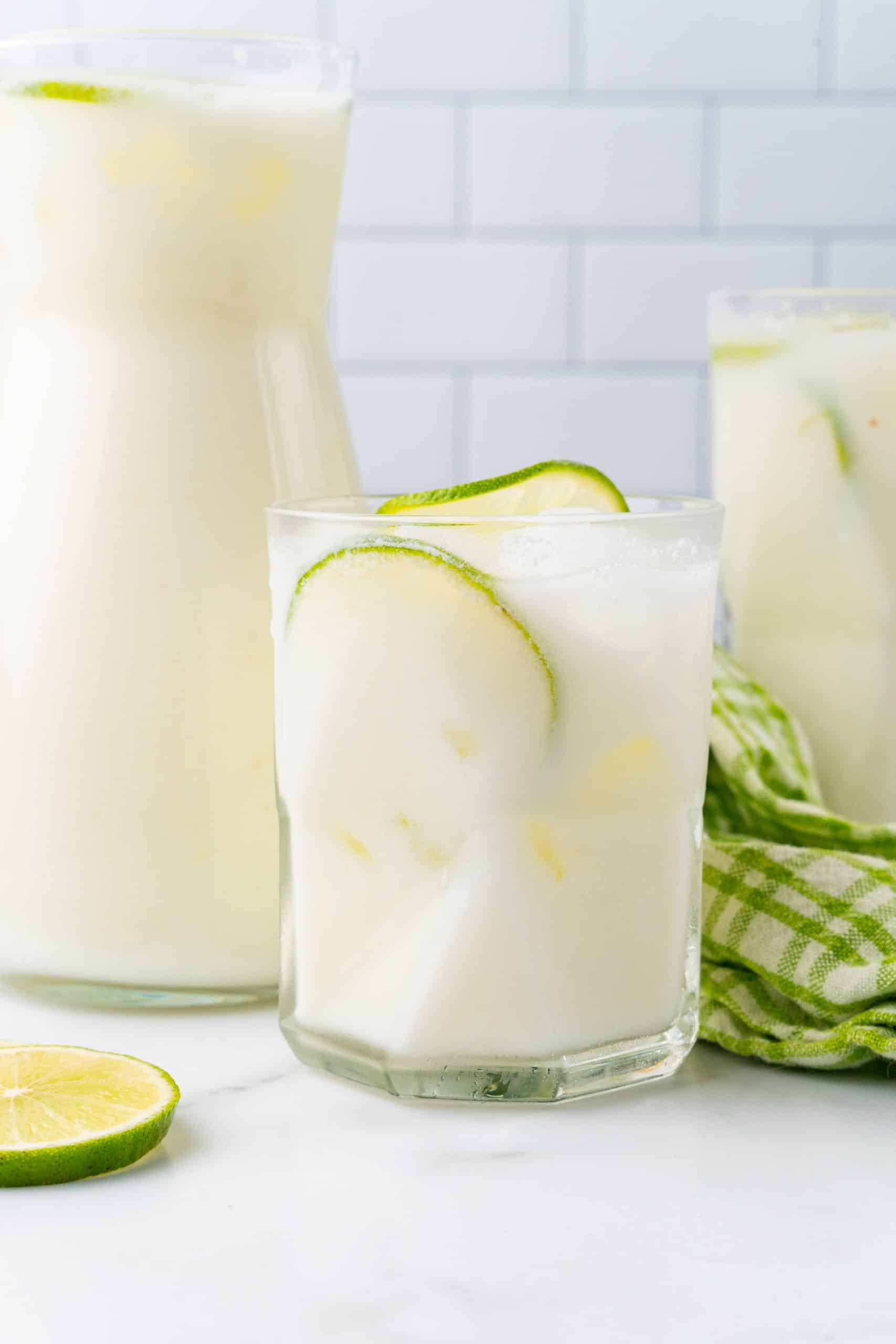 creamy limeade in a glass with ice cubes and lime slices