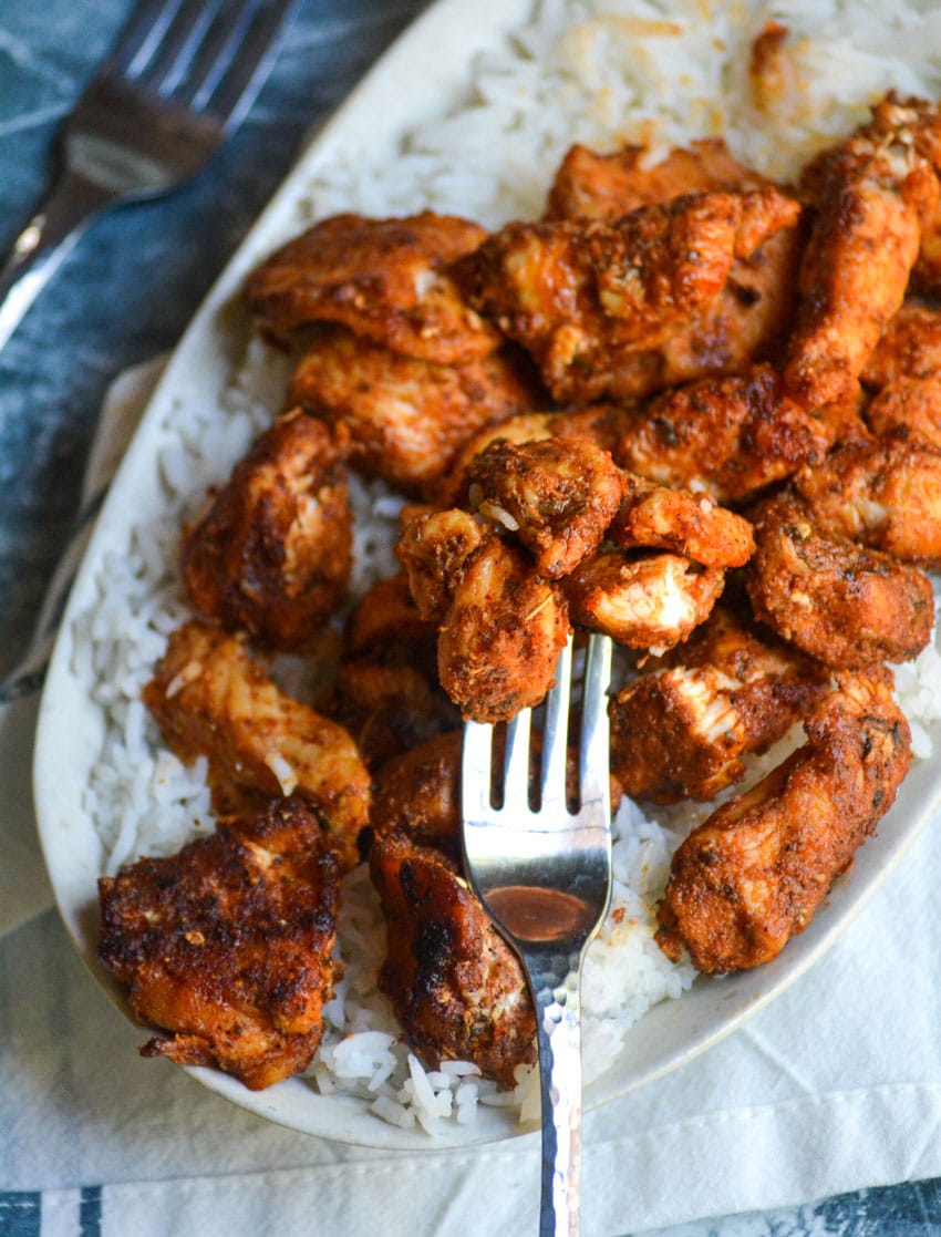 a silver fork holding up blackened chicken bites