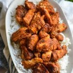 blackened chicken bites over white rice in a small dish