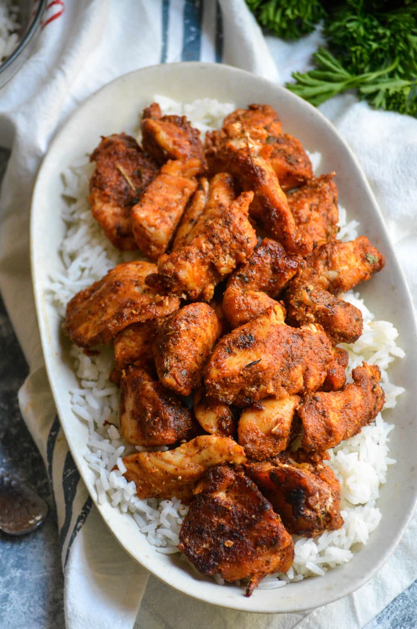 blackened chicken bites over white rice in a small dish