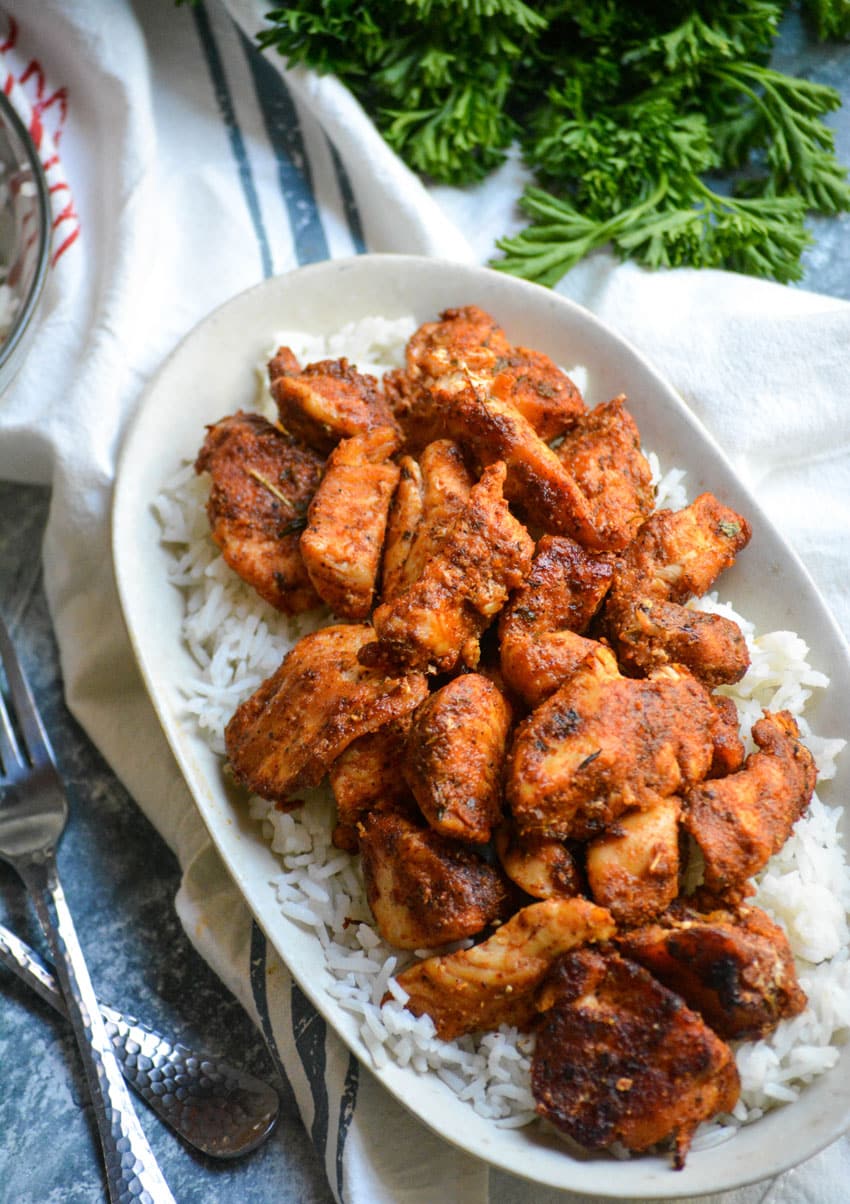 blackened chicken bites over white rice in a small dish