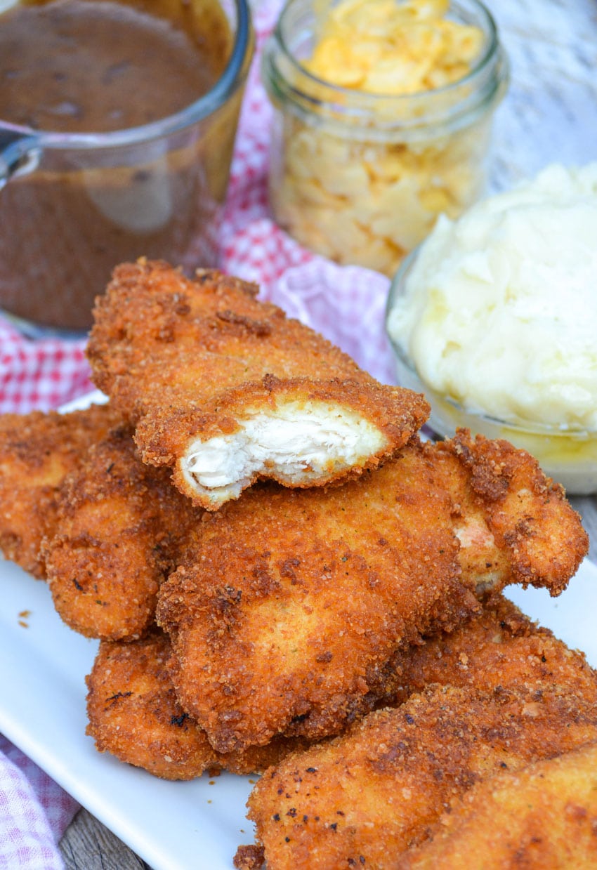 potato flake chicken strips piled on a white serving plate