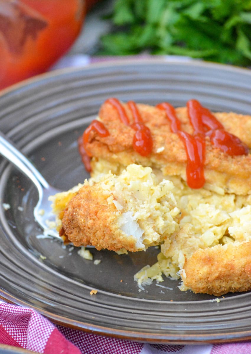 a silver fork cutting into a slice of frozen fish stick casserole