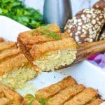 a wooden spatula holding up a slice of fish stick casserole