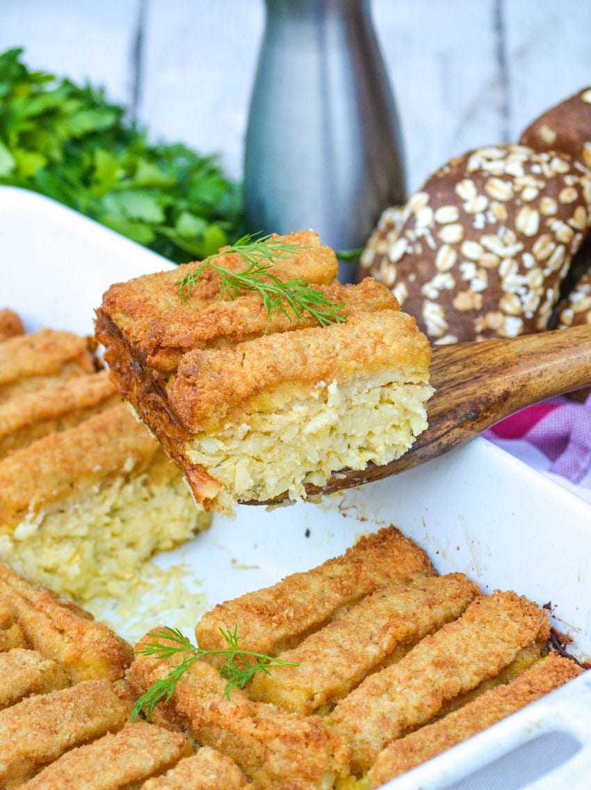 a wooden spatula holding up a slice of fish stick casserole