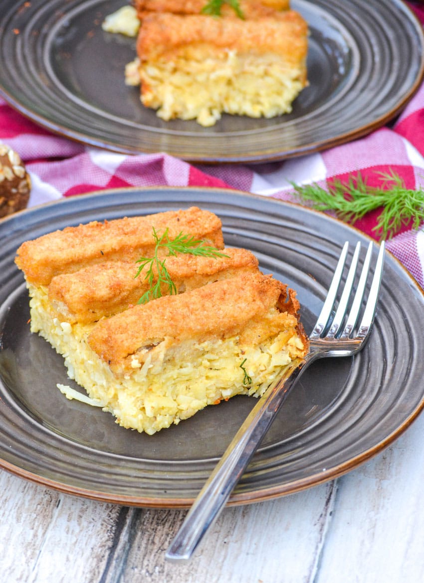 a slice of frozen fish stick casserole on a brown plate with a silver fork resting on the side