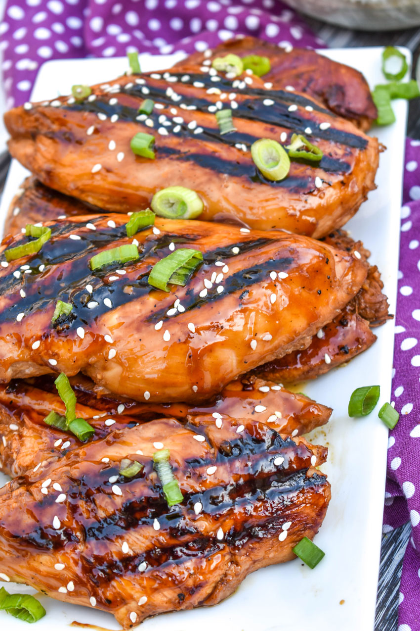 pieces of grilled huli huli chicken stacked on a white platter