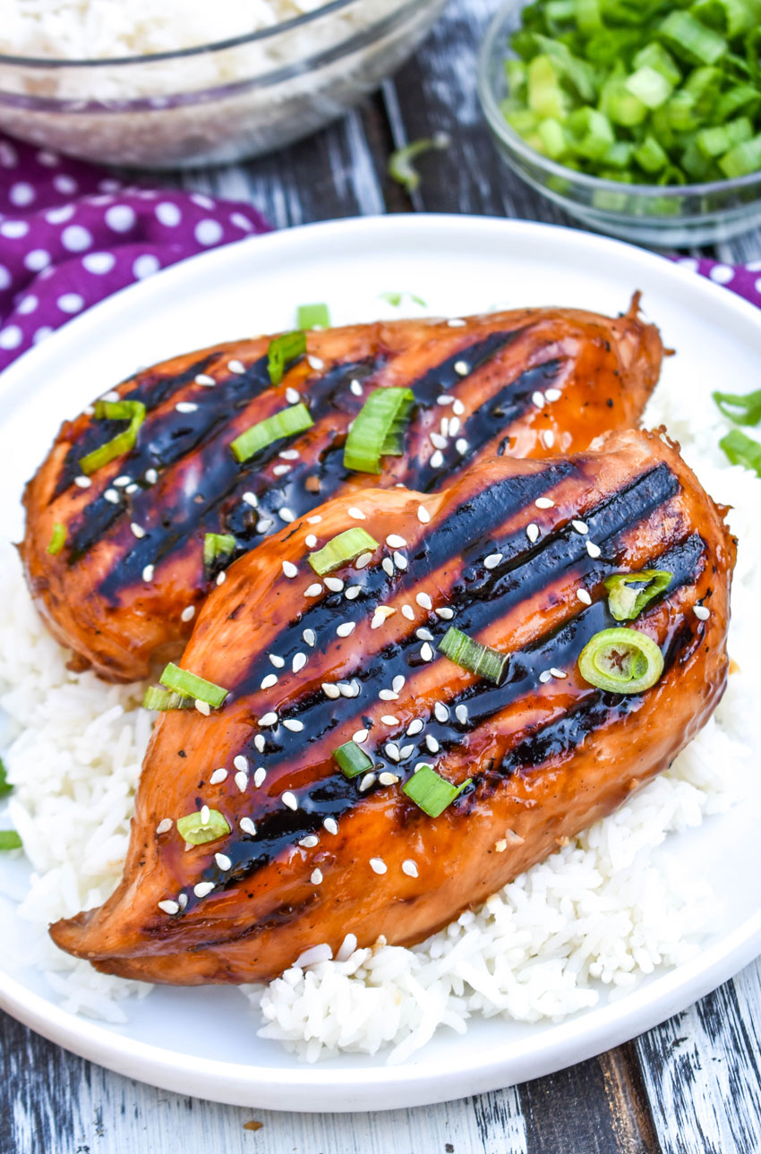 grilled huli huli chicken over steamed white rice on a white plate