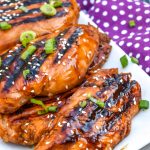 pieces of grilled huli huli chicken stacked on a white platter