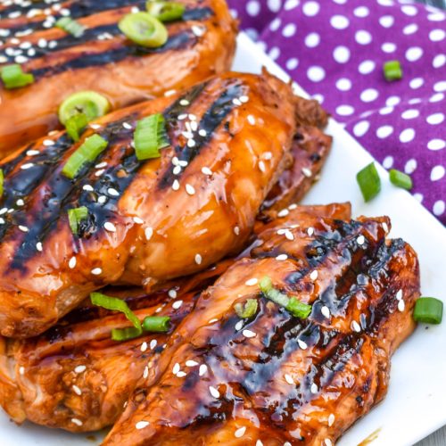 pieces of grilled huli huli chicken stacked on a white platter