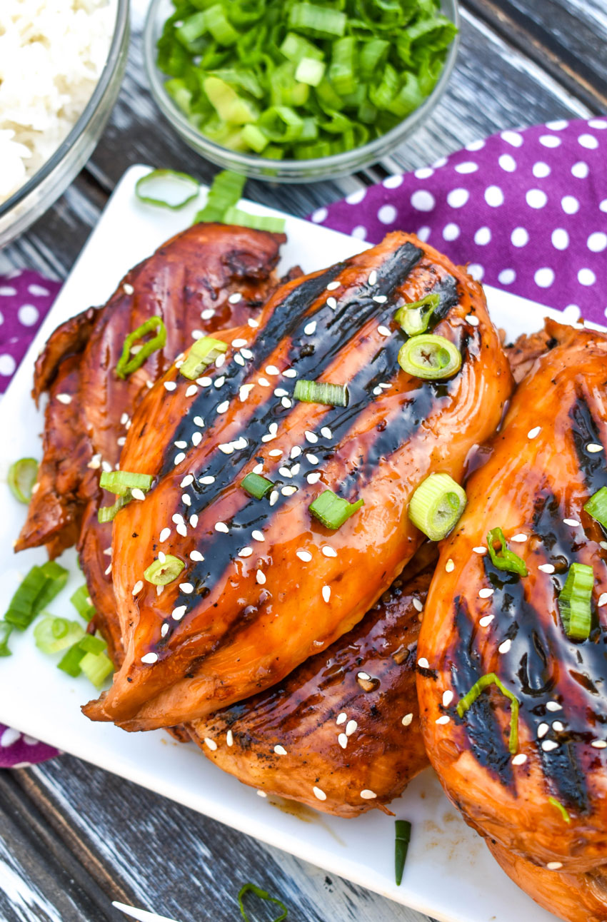 pieces of grilled huli huli chicken stacked on a white platter