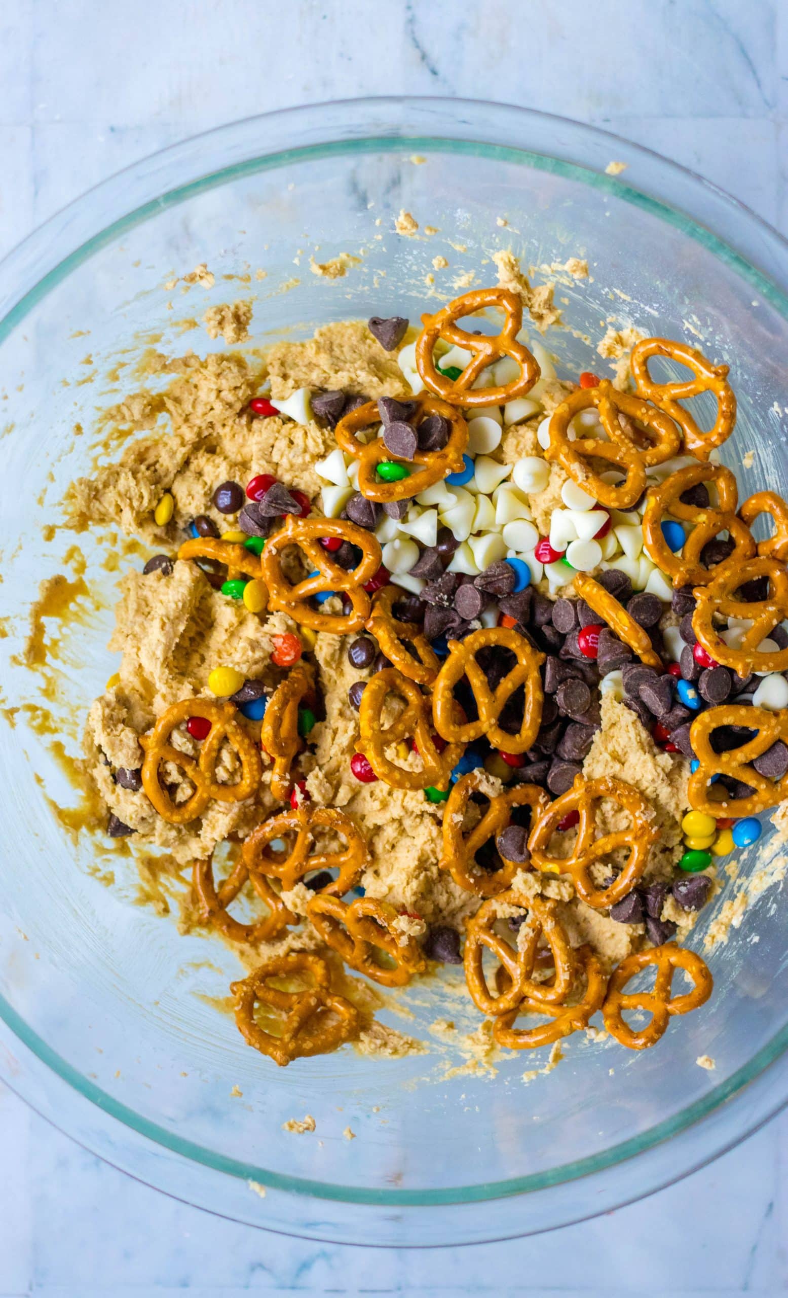 candy pieces in a glass mixing bowl filled with edible cookie dough