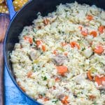 one pot chicken and rice with vegetables in a blue cast iron skillet