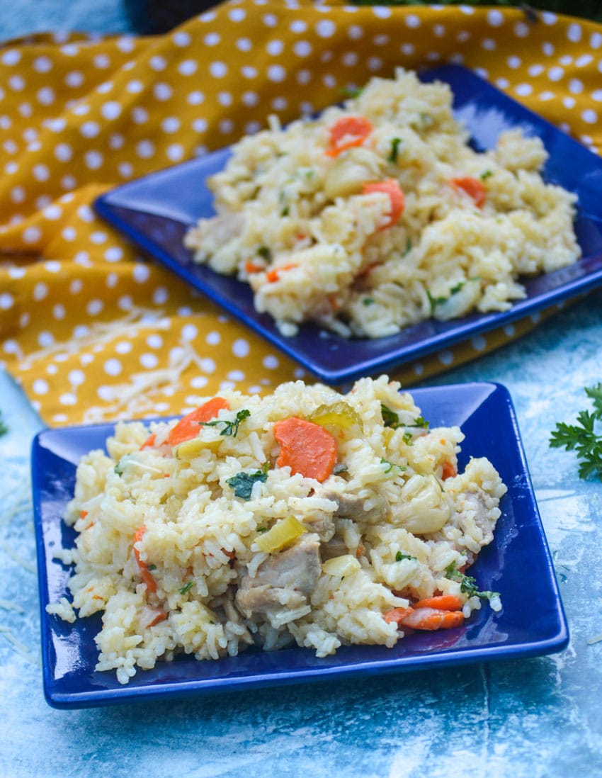 one pot chicken and rice with vegetables on two small blue square plates