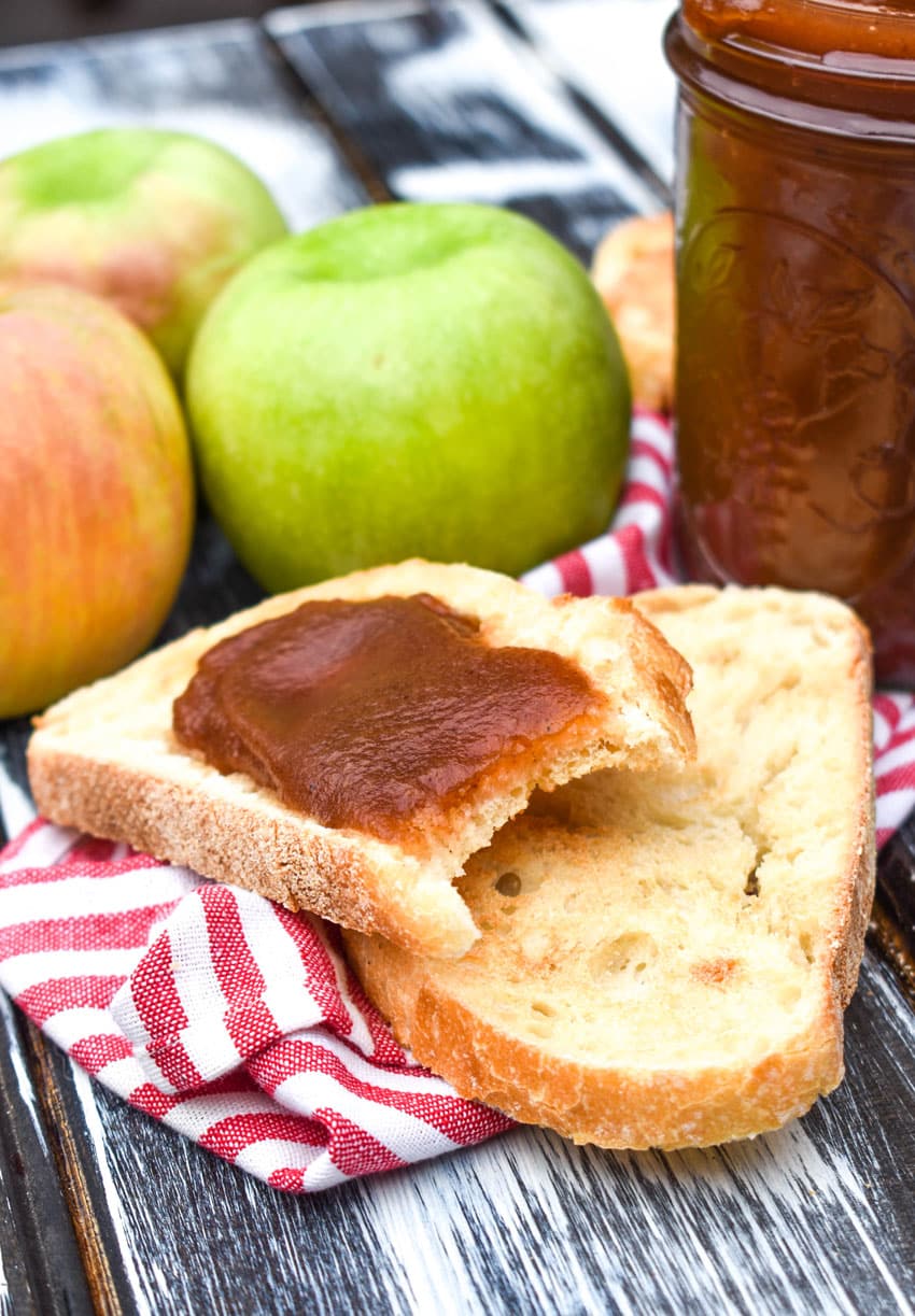 crockpot apple butter spread on a bitten slice of toasted bread