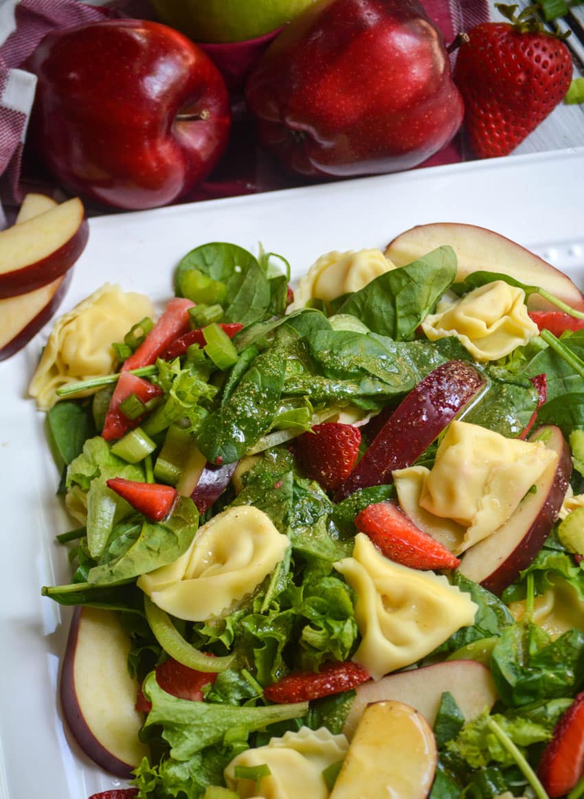 spinach tortellini salad on a white serving platter