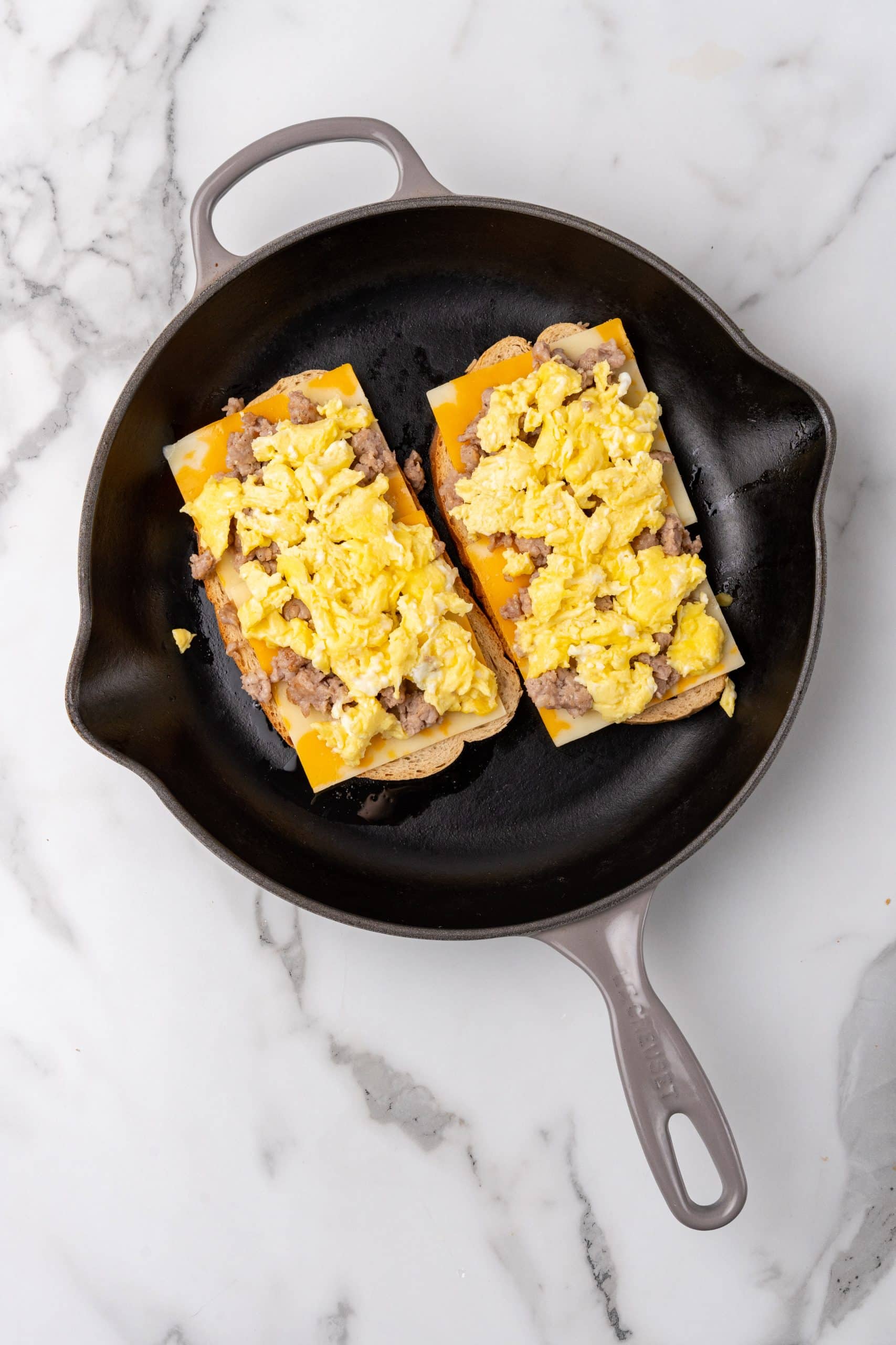 open faced breakfast grilled cheese sandwiches in a small black skillet