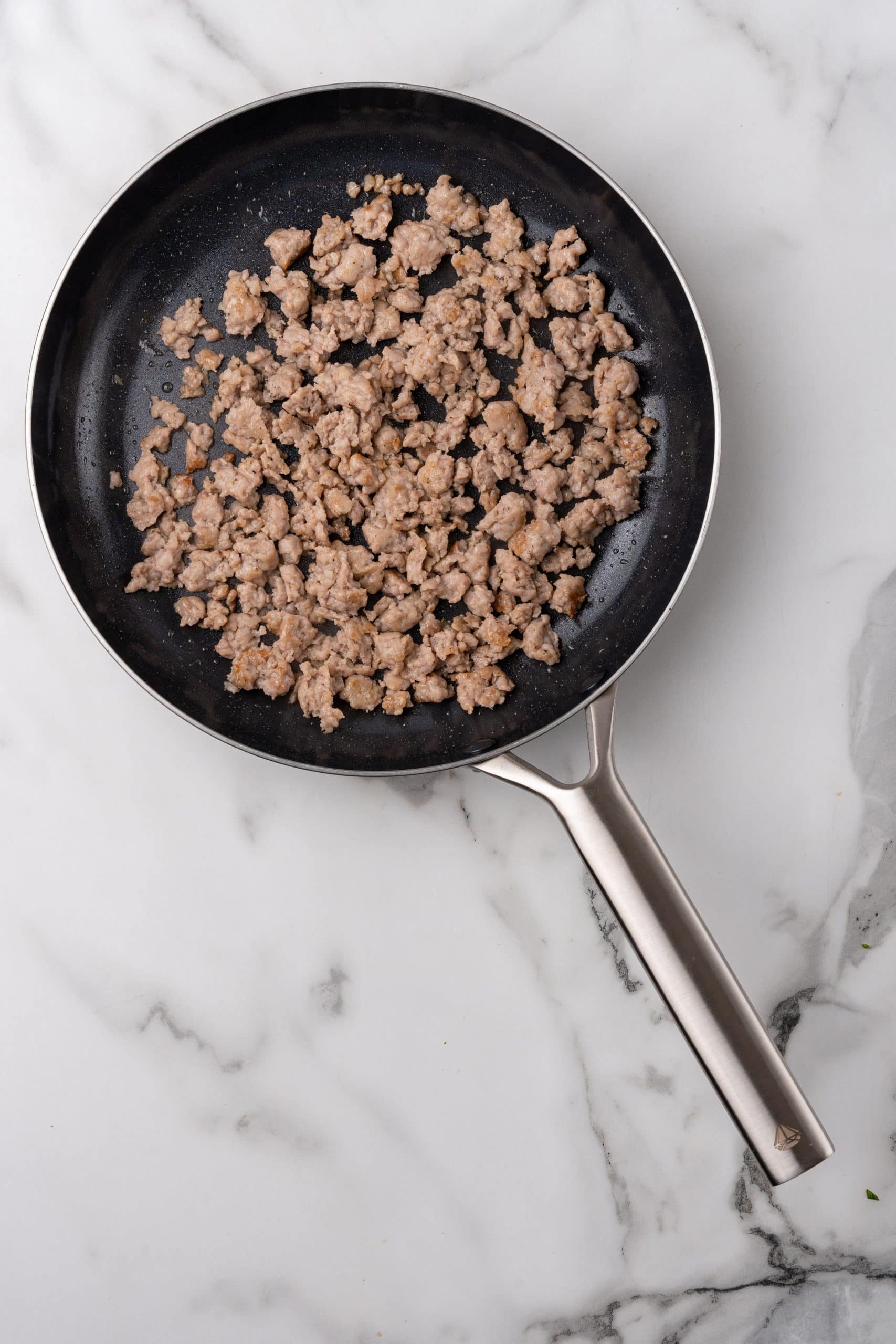 cooked crumbled sausage in a small black skillet