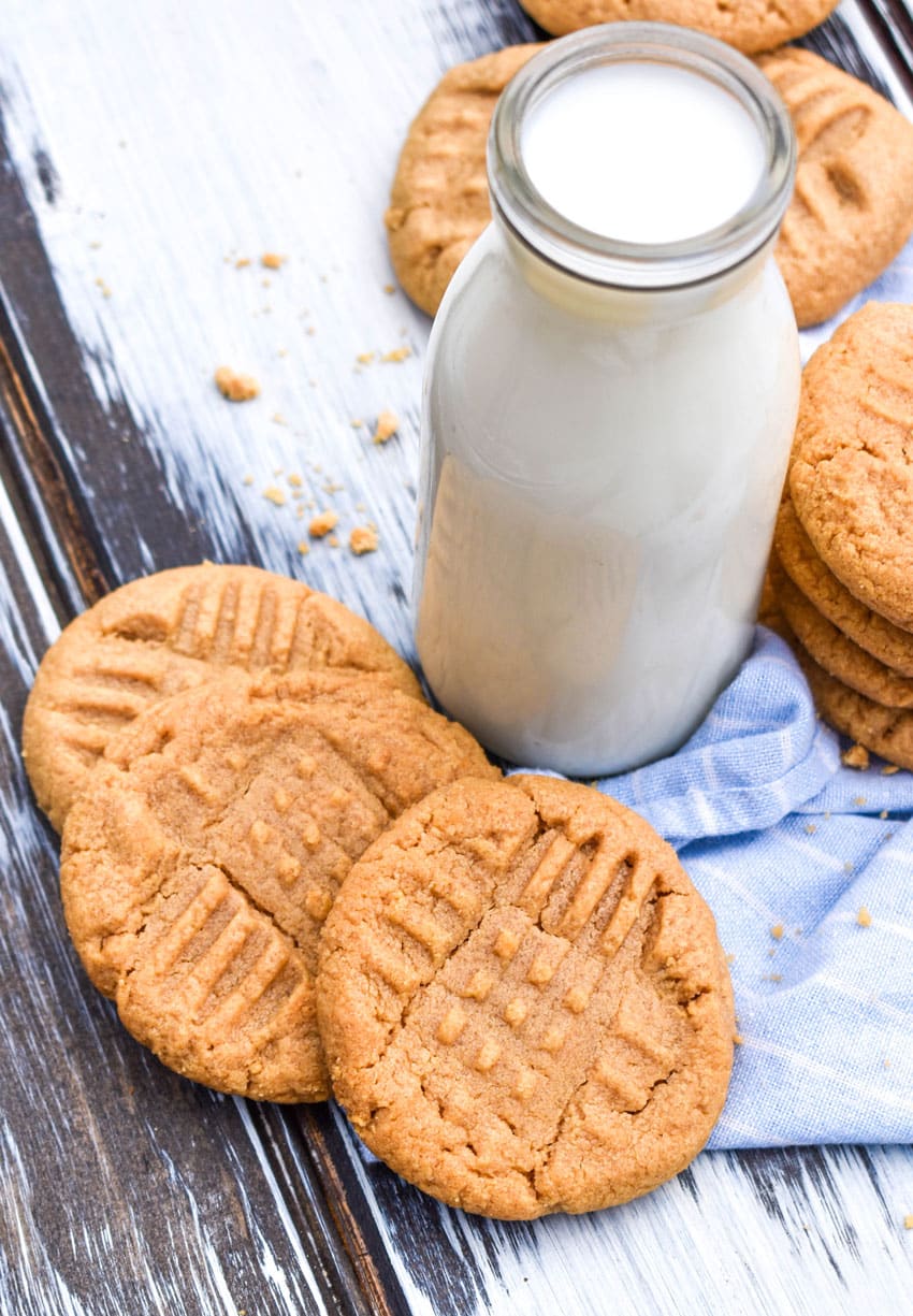 Three Ingredient Peanut Butter Cookies three ingredient peanut butter cookies stacked around a glass jar of milk