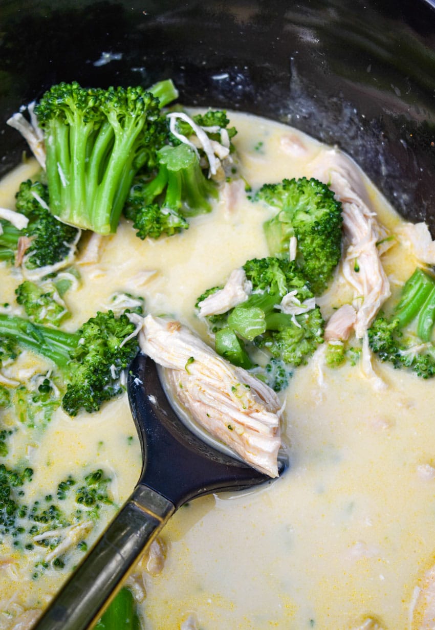 creamy chicken and broccoli in the black crock of a slow cooker