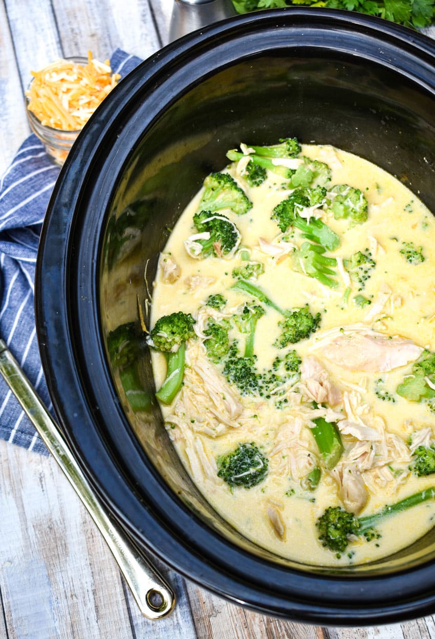 creamy chicken and broccoli in the black crock of a slow cooker