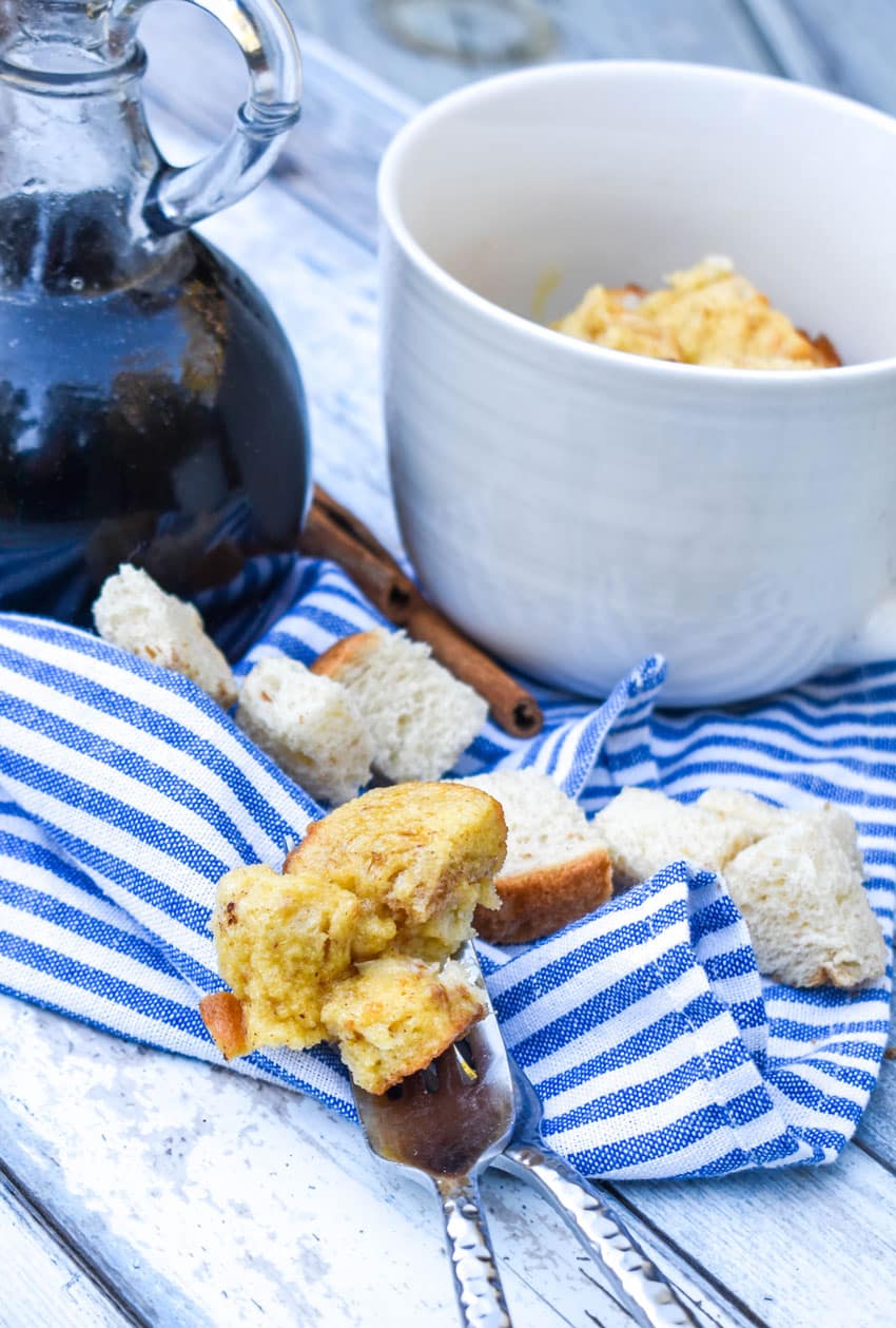 a silver fork scooping french toast in a mug out of a white cup