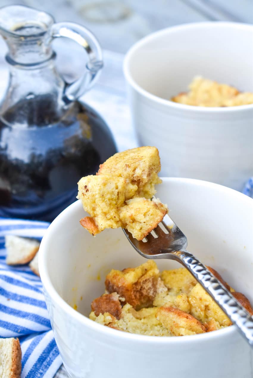 a silver fork scooping french toast in a mug out of a white cup