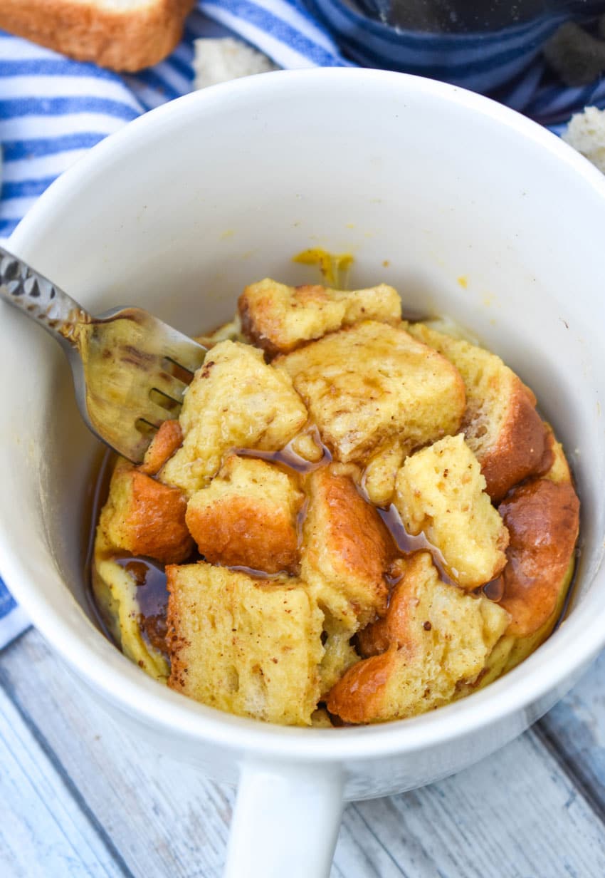 a silver fork in a white mug filled with french toast