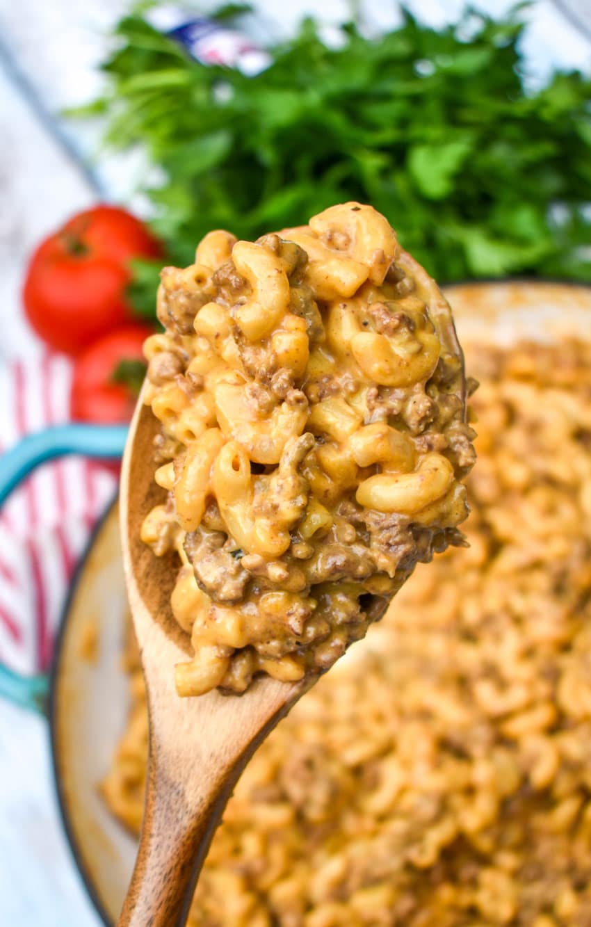 a wooden spoon holding up a scoop of creamy hamburger helper from scratch